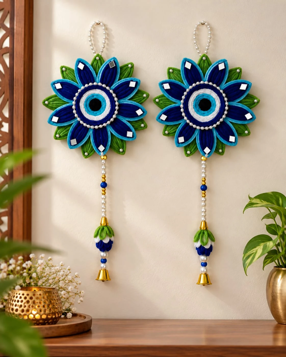 Neel Nazar Duo: A matching pair of blue nazar-inspired flower hangings with green leaves, pearl-like strings and golden bells.