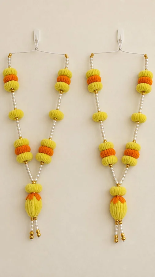 Yellow and orange floral garlands with pearl-like beads, gold-toned accents and hanging buds. A pair is pictured.