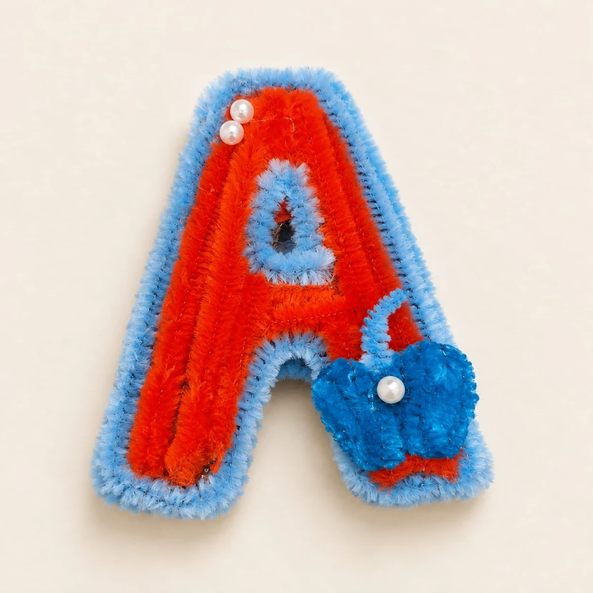 Little Initial A: An orange initial A keychain with a blue outline, a small blue heart and pearl-like details.
